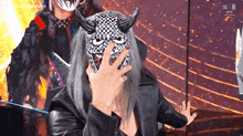 a person wearing a mask with horns on their face .
