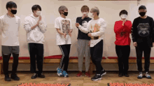 a group of young men wearing face masks are standing next to each other