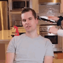 a man is getting his hair cut by a woman