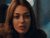 a close up of a woman 's face with a slight smile on her face