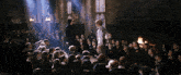 a large group of people are gathered in a room with two people standing in front of them