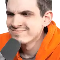 a man in an orange hoodie is talking into a microphone and making a funny face