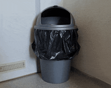 a garbage can with a black bag on it