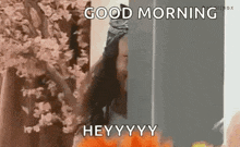 a woman is standing in front of a refrigerator and saying `` good morning hey ! ''