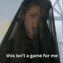a woman wearing a black veil with the words " this isn 't a game for me " below her