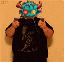 a man wearing a monster mask is holding a pair of remote controls