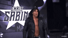 a wrestler named chris sabin is standing in front of a large star