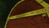 a close up of a red and gold item with holes in it