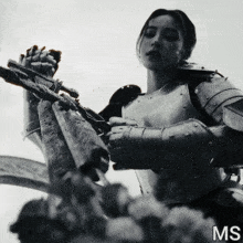 a black and white photo of a woman in armor with the letters ms underneath her