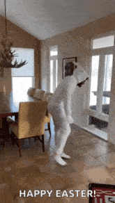 a person in a bunny costume is dancing in a living room with a table and chairs .