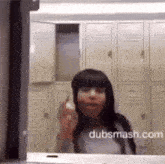 a woman is giving the middle finger in front of a mirror with dubsmash.com written on the bottom