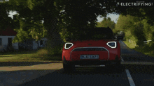 a red mini cooper with the license plate m ac 1367 e drives down a road