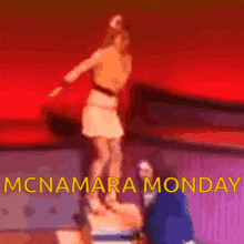 a statue of a woman standing on a pedestal with the words mcnamara monday in yellow
