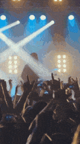 a crowd of people at a concert with their hands up