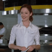 a woman wearing a white shirt with a name tag that says ' ashley ' on it