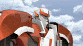 a close up of a red and white robot against a cloudy sky