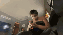 a boy wrapped in a towel is playing with a toy gun