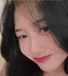 a close up of a woman 's face with black hair and red lipstick