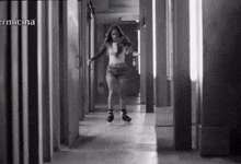 a woman rollerblading in a hallway with the word ermicina on the bottom right