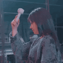 a woman is holding up a white object in her hand