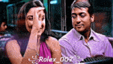 a man and a woman are sitting next to each other with rolex 007 written on the bottom right