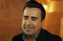 a man in a suit is smiling and looking at the camera