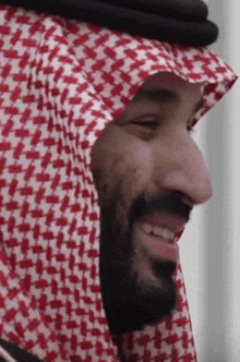 a man wearing a red and white checkered head scarf