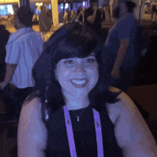 a woman wearing a lanyard with the number 4 on it smiles for the camera