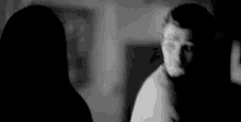 a man and a woman are standing next to each other in a dark room .
