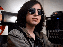 a young man wearing sunglasses and a jacket with a gifs watermark