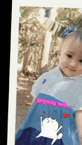 a little girl wearing a blue and white dress with the words goyang nek on the bottom
