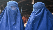 a woman in a blue veil is standing next to another woman