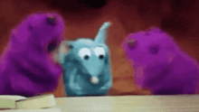 a group of purple stuffed animals are sitting on a table .