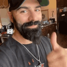 a man with a beard is giving a thumbs up sign