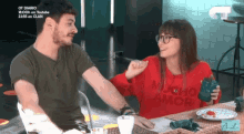 a man and a woman are sitting at a table and the man is wearing a green shirt that says diario