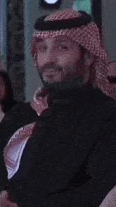 a man wearing a black shirt and a red and white head scarf