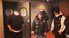 a group of people wearing masks are standing in a room