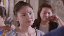 a woman is making a funny face while standing next to a man in a room .