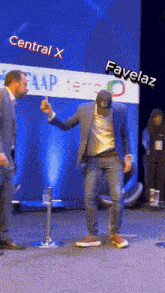 a man dancing in front of a sign that says central x on it