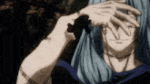 a close up of a person covering their eyes with their hands