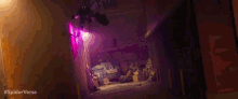 a person is flying through the air in a dark alleyway with purple lights .