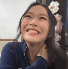 a close up of a woman 's face with a flower in her hair