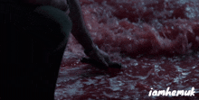 a person 's hand is reaching into a pool of red liquid with the words iamhemuk below