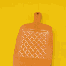 a person is holding a piece of chocolate on a wooden tray