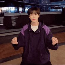 a young man wearing a purple jacket and a white t-shirt