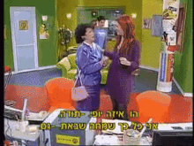 a woman in a purple dress shakes hands with another woman in an office