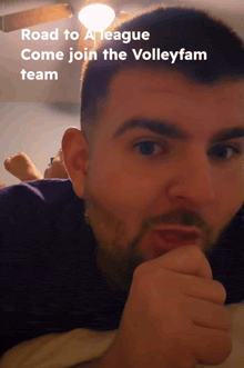 a man with a beard is laying down with the words road to a league come join the volleyfam team below him