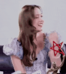 a woman is sitting on a couch holding a red star .