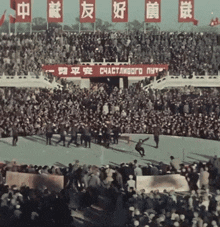 a crowd of people are gathered in a stadium with a sign that says " счастливого путя "