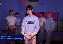 a group of young men are standing in front of a wall and one of them is wearing a sweatshirt that says bet